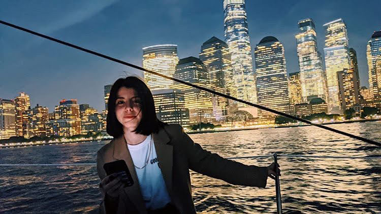 woman on a night cruise NYC in front of the shining World Trade Center