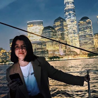NY night cruises with a woman in front of the shining buildings and skyline