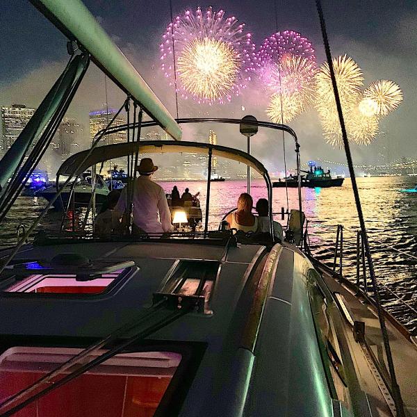 fireworks behind a sailboat during a July 4th boat cruise NYC