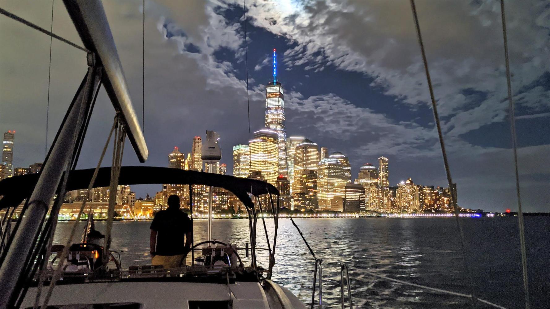 night boat tour of NYC on a private sailboat with the skyscrapers of the Financial District shining in the dark