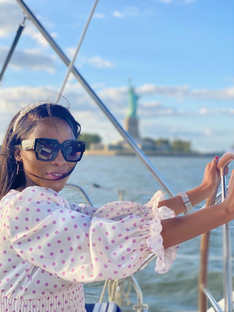 woman behind the helm on a sailboat ride in NYC
