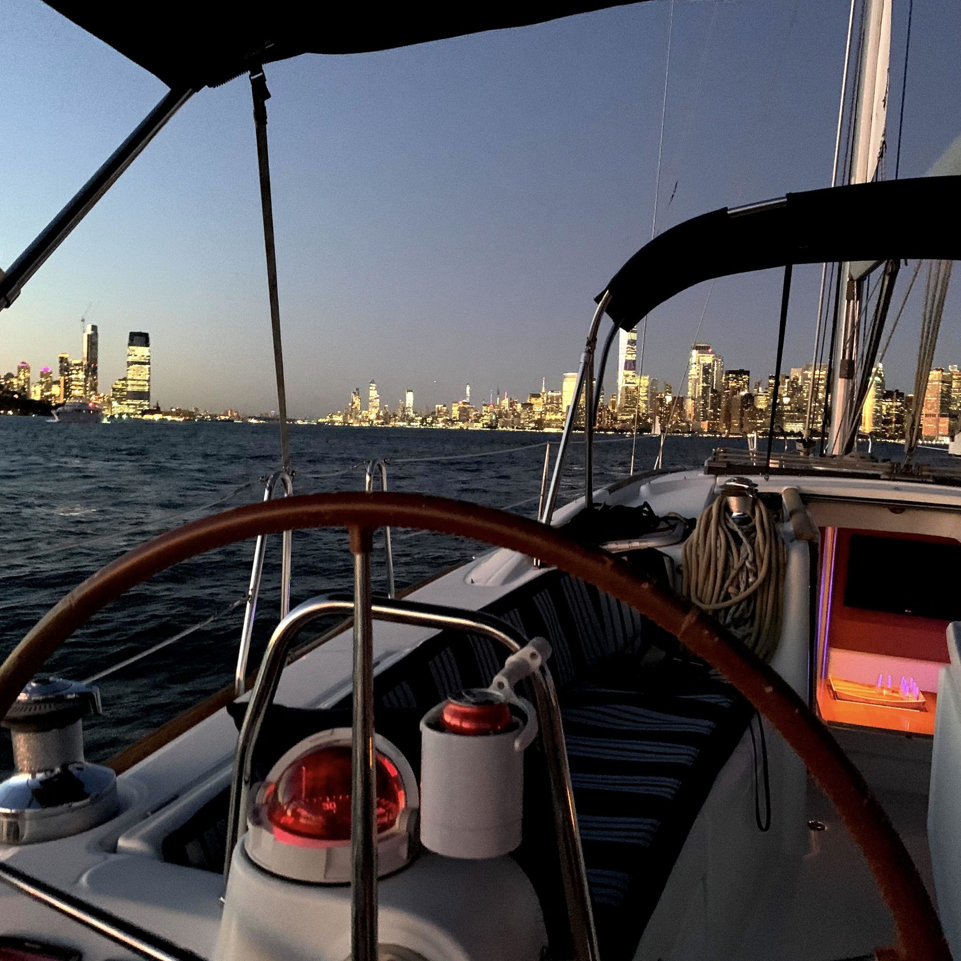 view from the sailboat cockpit during a night boat ride NYC