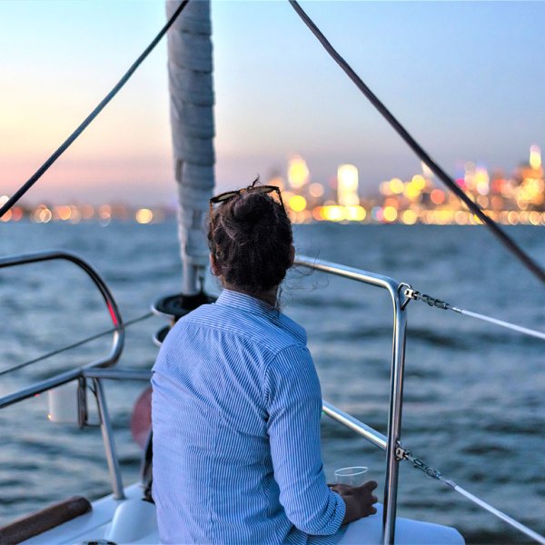 woman facing the NY Harbor while private sailing NYC