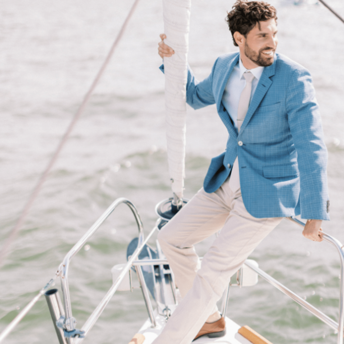 man in a blue jacket at the bow of a boat while sailing New York