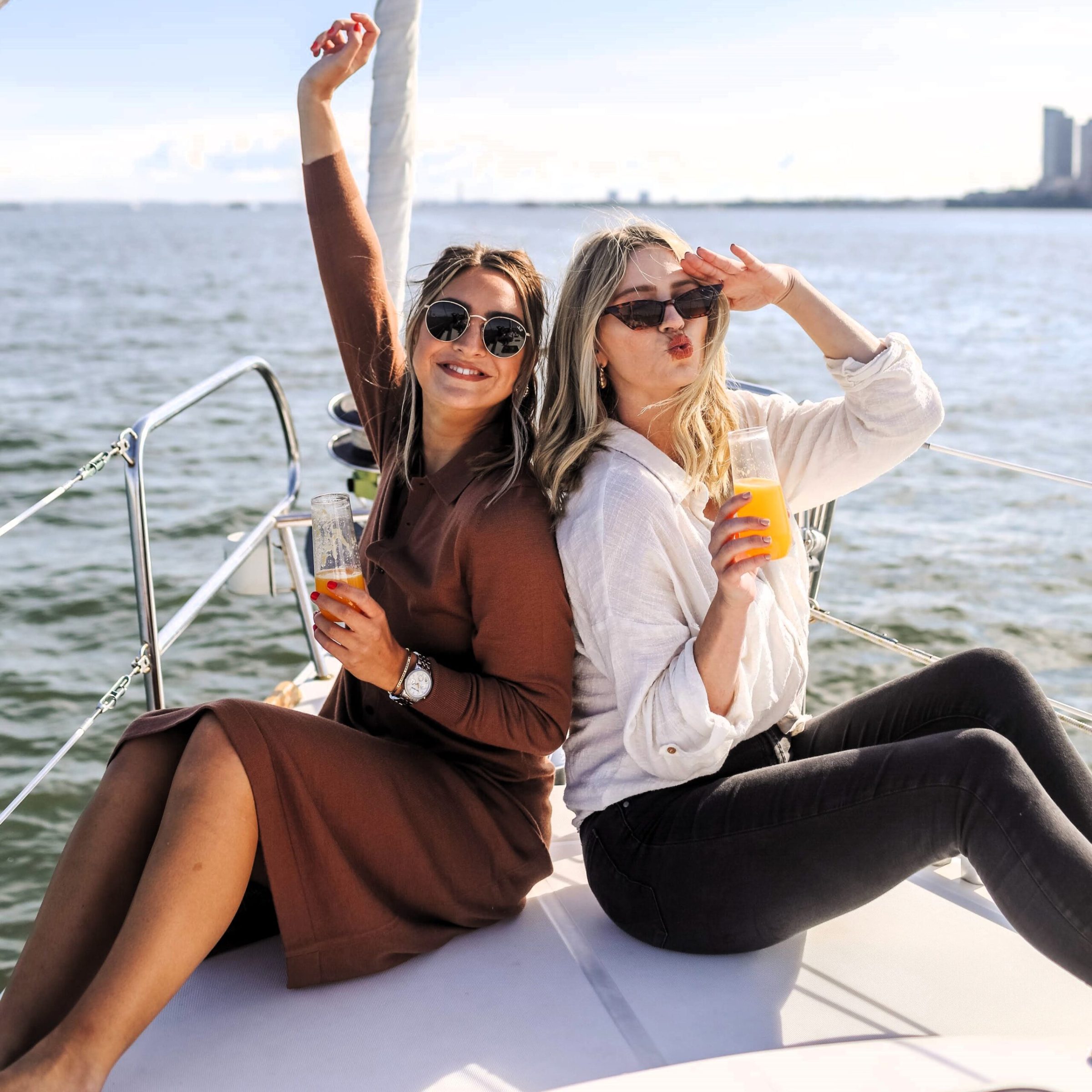 two women sitting on the bow of a boat during a boat brunch in NYC