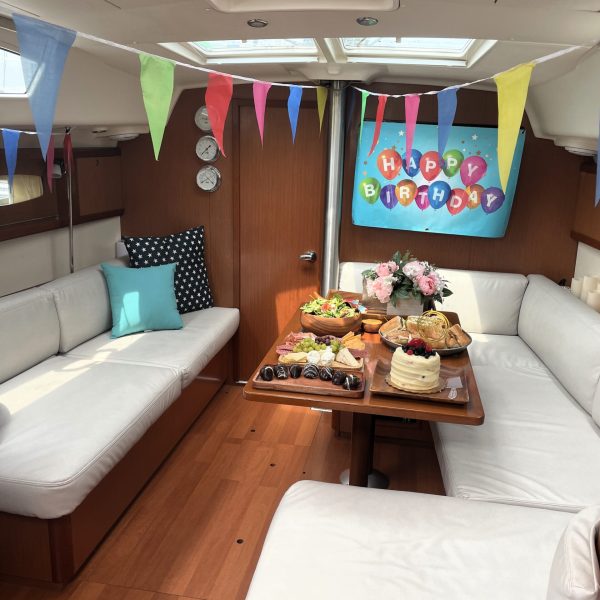 indoor cabin of a small party boat rental with wood paneling and white upholstery decorated for a small party boat rental in NYC