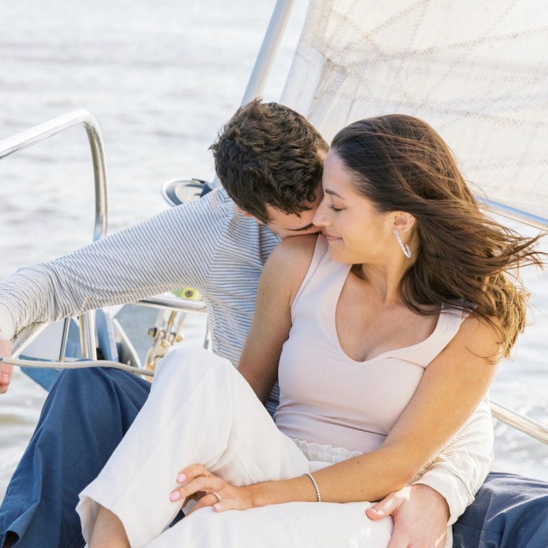 man in blue shirt and woman in white looking at each other during a nyc private boat rental