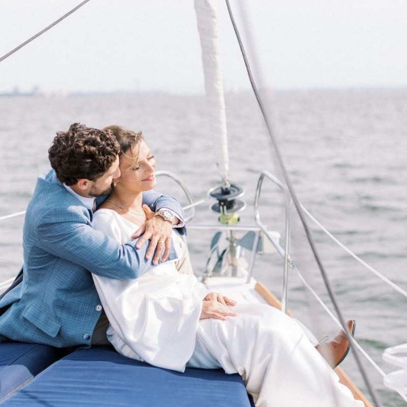 couple sitting on a blue cushion at sea during a yacht proposal in NYC