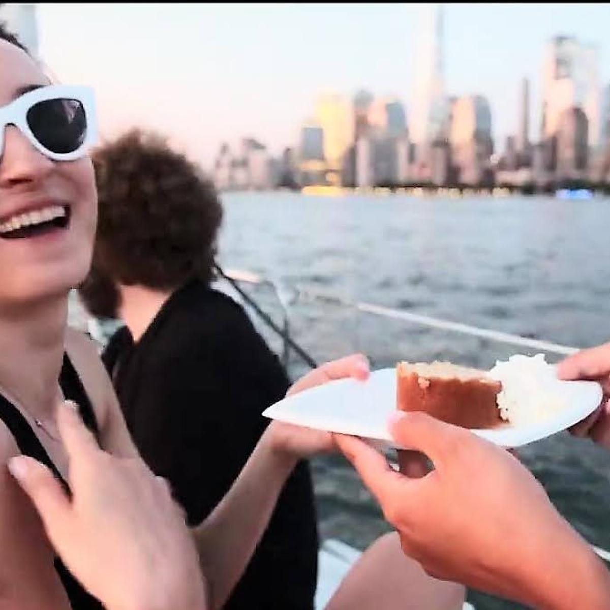 a woman wearing sunglasses posing for the camera on a sail cruise of NYC