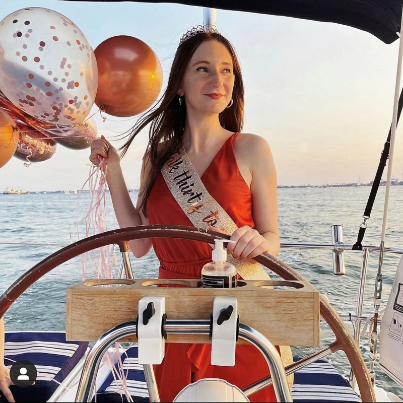 woman holding balloons for her birthday on a NYC private boat party