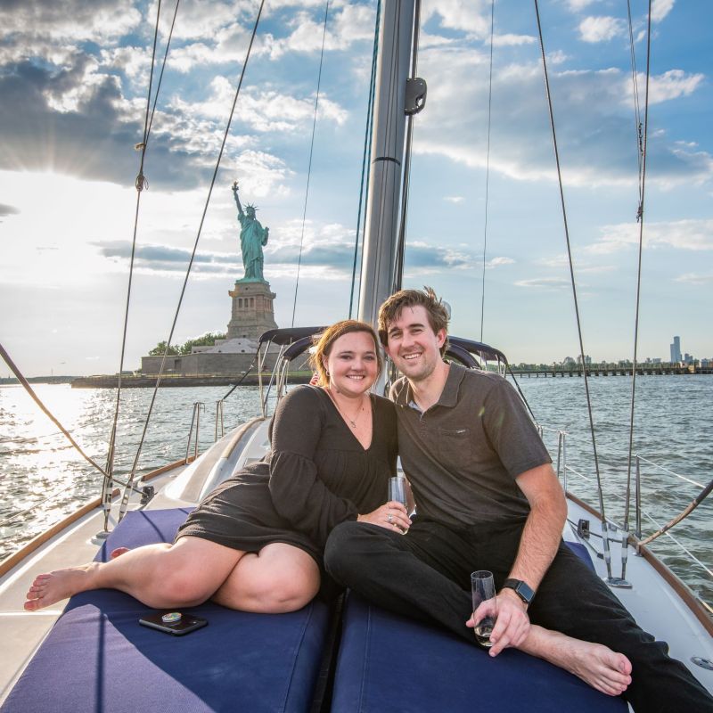 couple sitting on deck after a Statue of Liberty proposal on a private boat