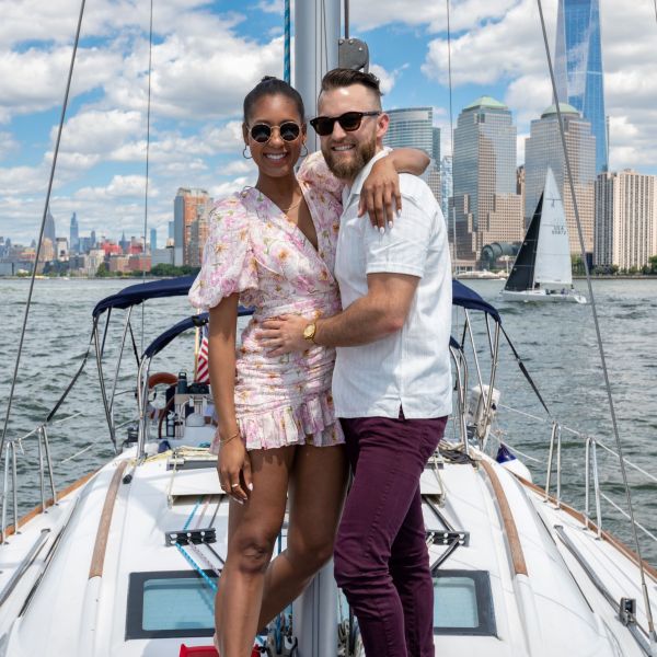 couple hugging and facing the camera on a romantic sailboat charter in NYC