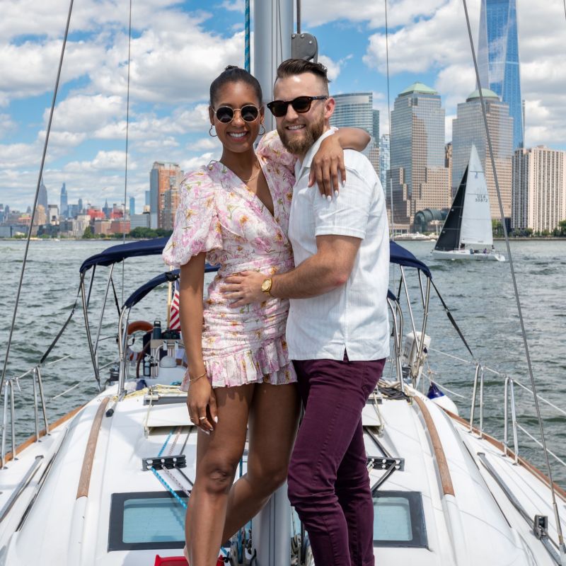 couple hugging and facing the camera on a romantic sailboat charter in NYC