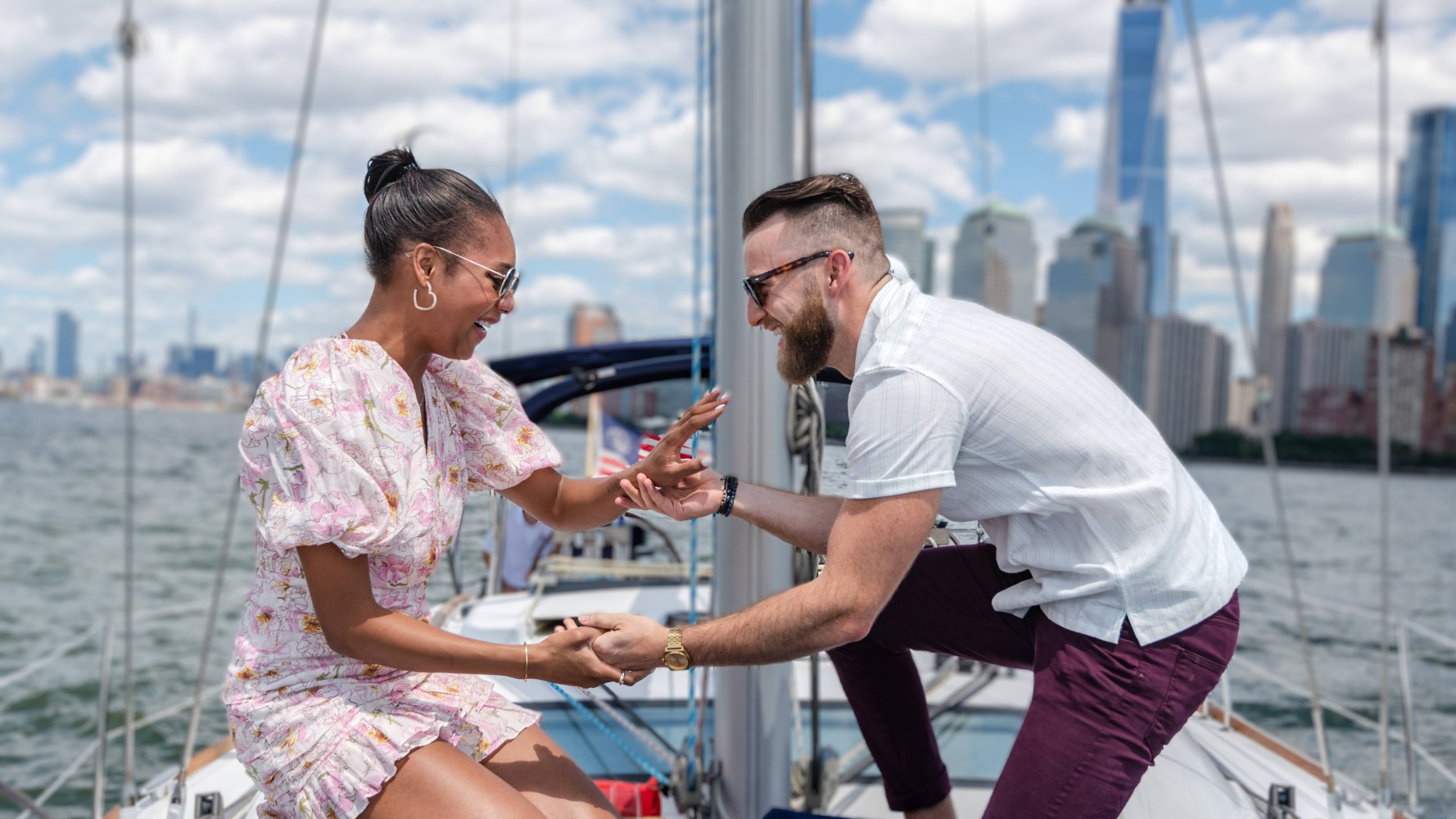 man kneeling on a boat proposing to a woman during a sailboat ride in NYC