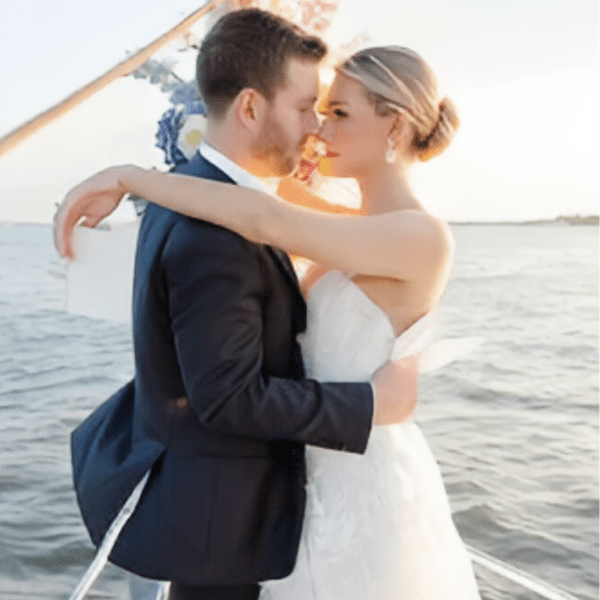 man and woman in a white dress looking romantically into each other's eyes making boat rides NYC romantic