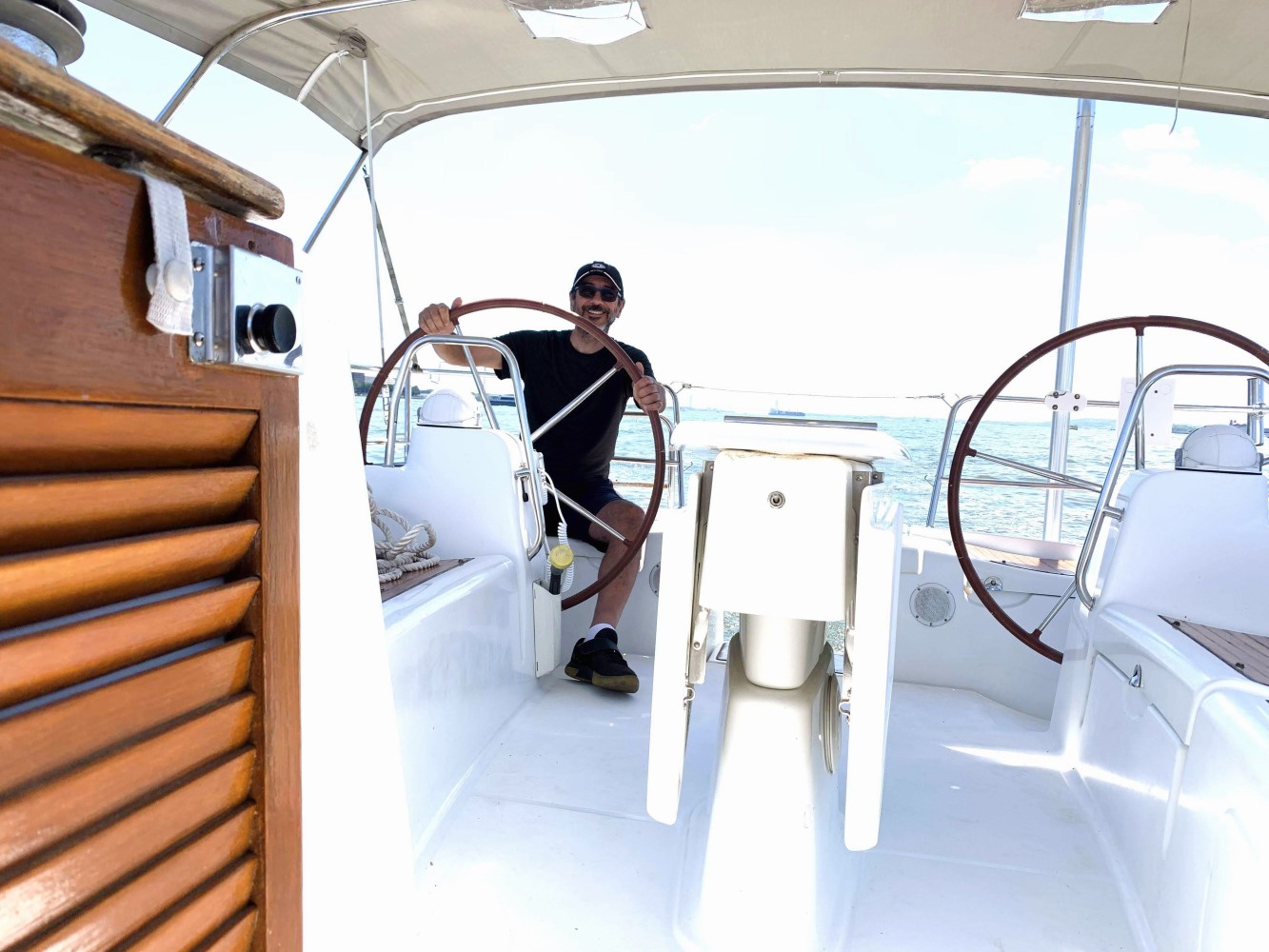 man at the helm of a sailboat rental nyc