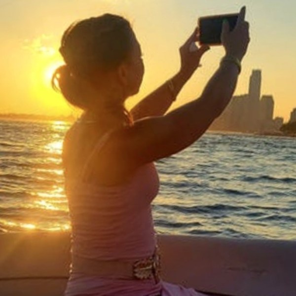 woman taking a picture during a sunset cruise in NYC