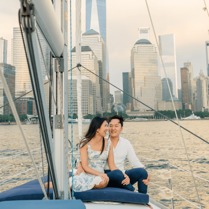 couple on a sailboat cruise in NYC with the financial district in the background