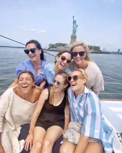 Bachelorette party celebration on private sailboat with champagne, Statue of Liberty in background