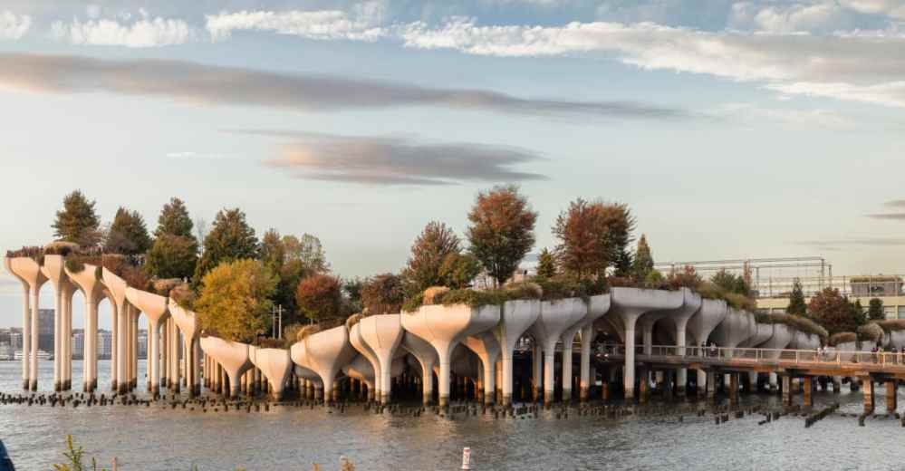 Little Island park with trees and white supports above water on a sunny boat tour in Chelsea NYC.