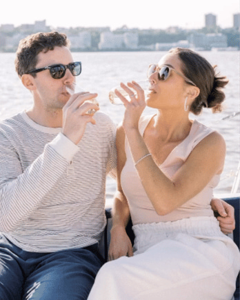 Couple drinking champagne while private sailing with NYC in the background.