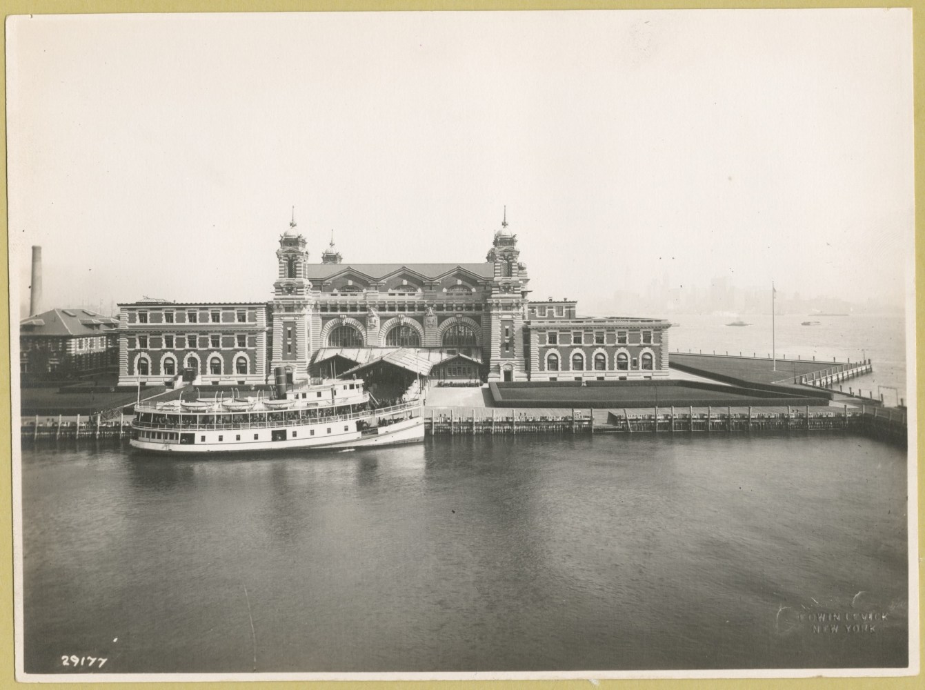 Historic photo of a ferry docked at Ellis Island immigration station.